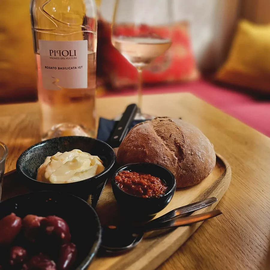 Brood met smeersels en olijven bij een glas rosé