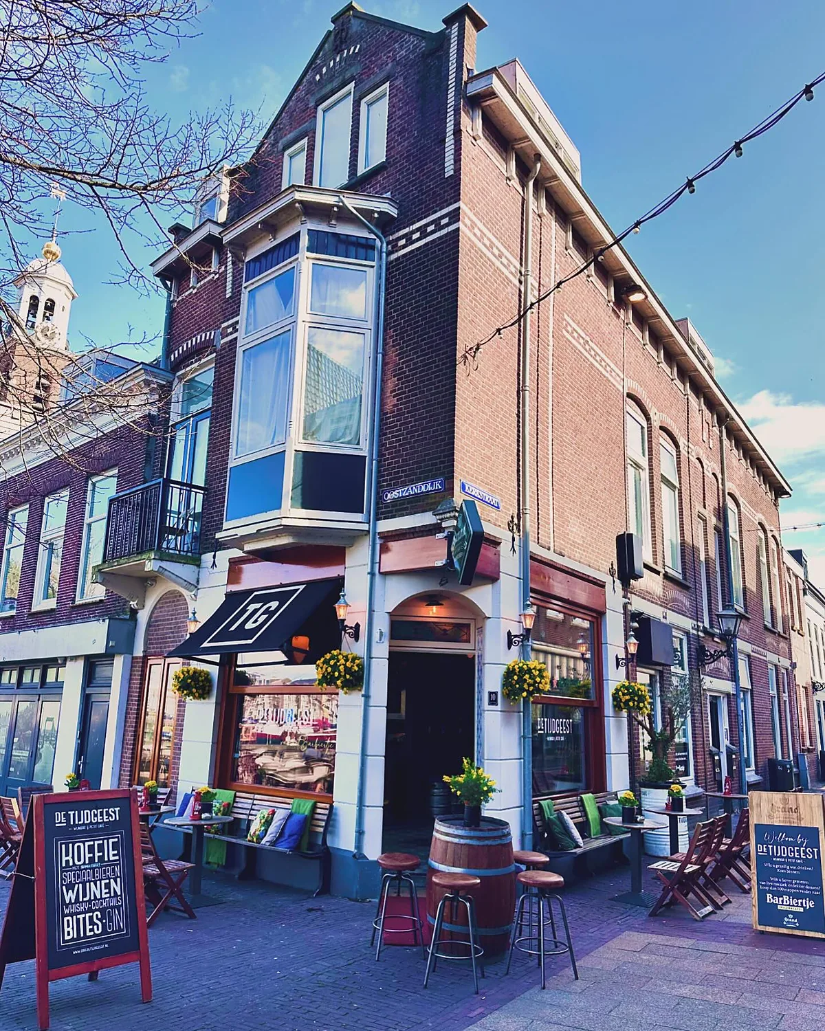 Het hoekpand van De Tijdgeest aan de Oostzanddijk, met het terras en de stoepborden
